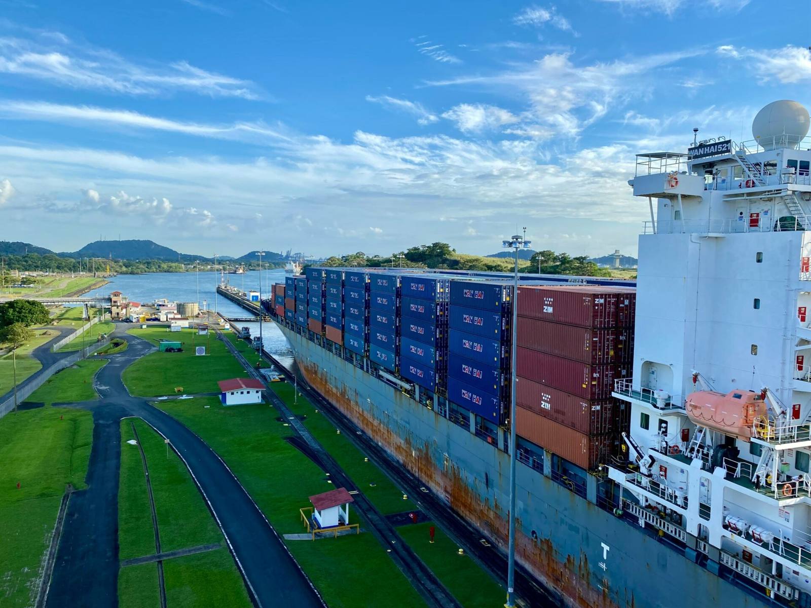 Aerial view of stacked shipping containers at a port terminal, the physical side of a regional supply chain